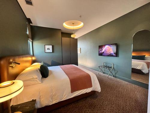 a hotel room with a bed and a tv at Home Suite Hotels Rosebank in Johannesburg