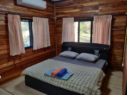 1 dormitorio con 1 cama con 2 almohadas en สายฝนการ์เด้น, en Ban On Luai
