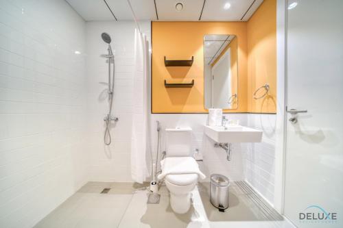 uma casa de banho com um WC, um lavatório e um chuveiro em Serene 2BR at The Nook Wasl Gate Jebel Ali by Deluxe Holiday Homes em Dubai