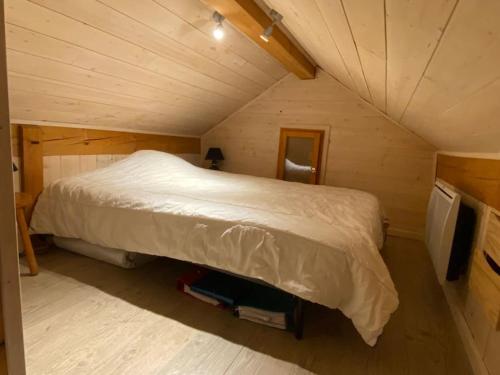 a bedroom with a large bed in a attic at Chalet paisible 6 personnes in Uvernet