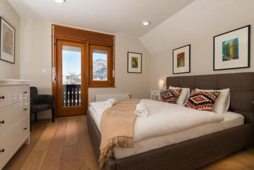 a bedroom with a bed and a dresser and a window at Mostnica Cottage in Bohinj