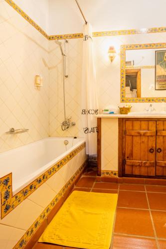 a bathroom with a tub and a sink at Monte das Lages in Redondo