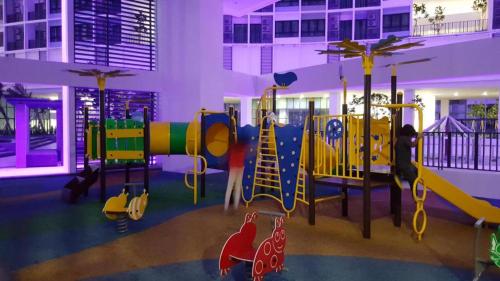 une aire de jeux avec des équipements colorés dans un bâtiment dans l'établissement LAVENDER Suite @ I-City, à Shah Alam