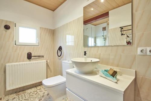 een badkamer met een wastafel, een toilet en een spiegel bij Casa Joanna by Mallorca House Rent in Portocolom