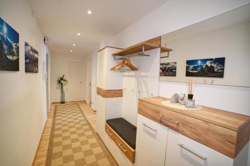 a kitchen with white cabinets and a checkered floor at Ferienwohnung im Herzen der Dolomiten in Carezza al Lago