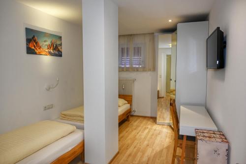een kleine kamer met 2 bedden en een bureau bij Ferienwohnung im Herzen der Dolomiten in Carezza al Lago