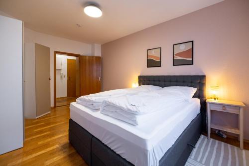 Un dormitorio con una cama grande con sábanas blancas. en Ferienwohnung in ruhiger Stadtlage, en Würzburg
