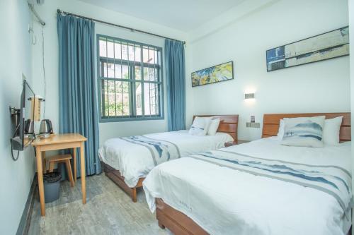 a hotel room with two beds and a window at Nanjing Tulou Xinyuan HomeStay in Nanjing