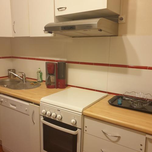 Il comprend une cuisine équipée d'une cuisinière blanche et d'un évier. dans l'établissement appartement 3 pièces, à Saint-Jean-de-Luz