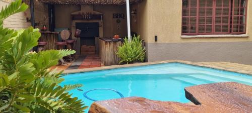 a swimming pool in front of a house at The Leopard Tree in Polokwane