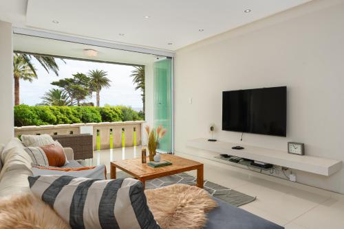 a living room with a couch and a tv at Sonnekus 5 in Cape Town