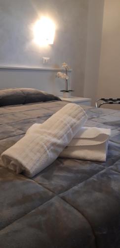 Locanda Il Burchiello في أورياجو دي ميرا: بطانية ملقاة على سرير مع مصباح عليه