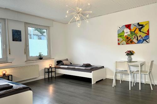 Cette chambre blanche comprend un lit, une table et des chaises. dans l'établissement Work & Stay in Kleve, à Clèves