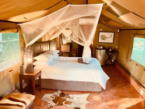 a bedroom with a bed with a canopy at Nyala Luxury Safari Tents in Marloth Park
