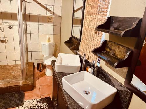a bathroom with a sink and a toilet and a shower at Nyala Luxury Safari Tents in Marloth Park