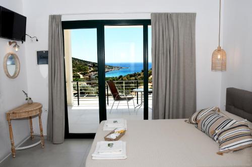 a bedroom with a bed and a view of the ocean at Karinta Bay Apartments in Chios