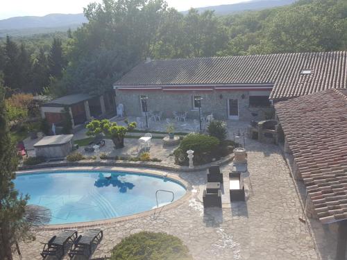 - une vue sur la piscine en face d'une maison dans l'établissement Mas de la berlusiere chambres d hotes en ardeche du sud, à Saint-André-de-Cruzières