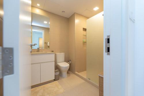 uma casa de banho com um WC, um lavatório e um espelho. em Stunning 3 bedroom townhouse in Townsquare em Dubai