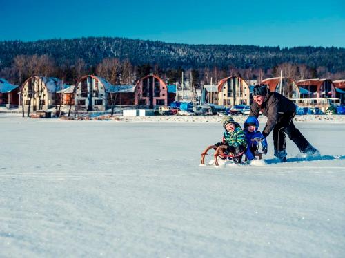 a man pulling a child on a sled in the snow at Landal Marina Lipno in Lipno nad Vltavou