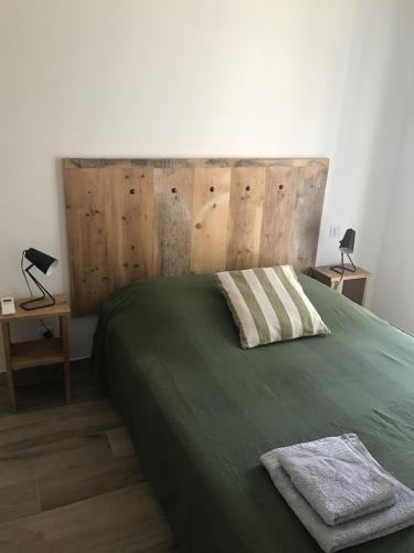 - une chambre avec un lit vert avec deux tables et deux lampes dans l'établissement Villa Agliastru à 900m de la plage de Lozari, à Belgodère