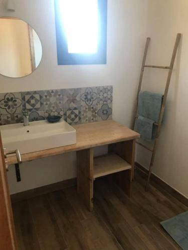 une salle de bain avec un lavabo et un miroir dans l'établissement Villa Agliastru à 900m de la plage de Lozari, à Belgodère