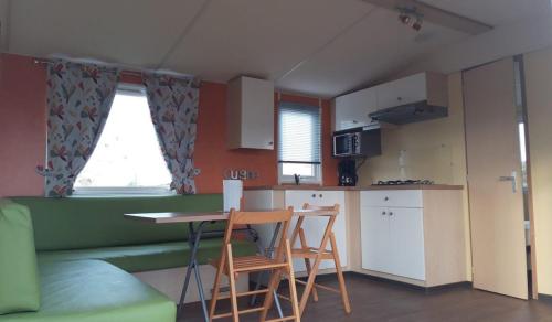 un salon avec une table et des chaises et une cuisine dans l'établissement Camping de la Rive, à Notre-Dame-de-Monts