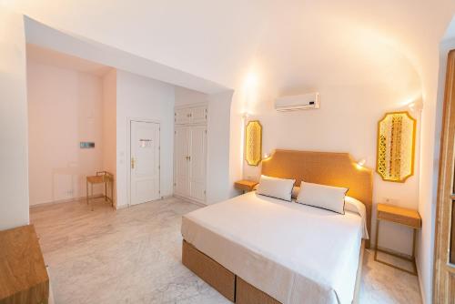 a bedroom with a large white bed in a room at Hotel La Chiquita in Córdoba