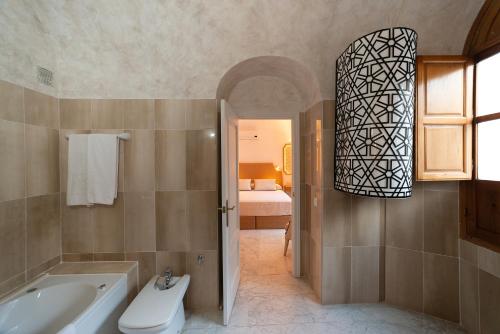 y baño con bañera, aseo y lavamanos. en Hotel Casa Palacio la Sal, en Córdoba