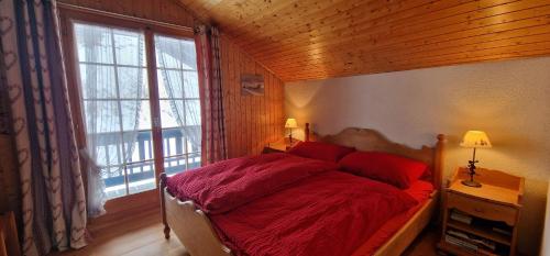 - une chambre avec un lit et une grande fenêtre dans l'établissement Lupin 32, à Champoussin