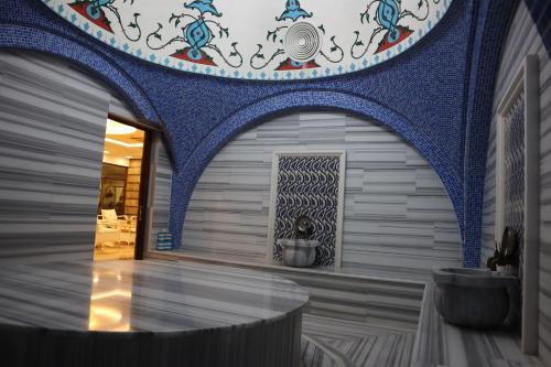 Cette chambre est dotée d'un plafond bleu et blanc. dans l'établissement GHERDAN GOLD OTEL, à Konya