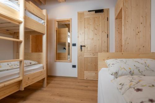 a bedroom with two bunk beds and a door at Planinska koča na Uskovnici in Srednja Vas v Bohinju