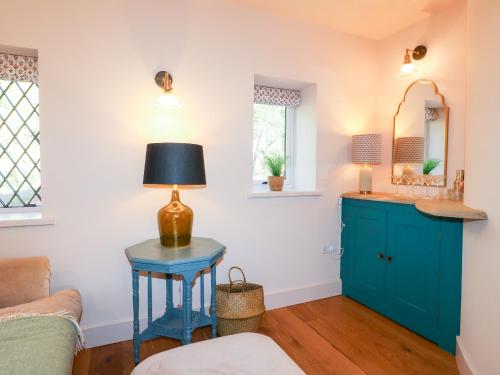 een woonkamer met een blauwe tafel met een lamp erop bij Woodland Lodge in Wolverhampton