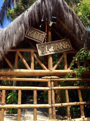 a restaurant with a thatch roof and a sign at Kitecabana Pousada in Cumbuco