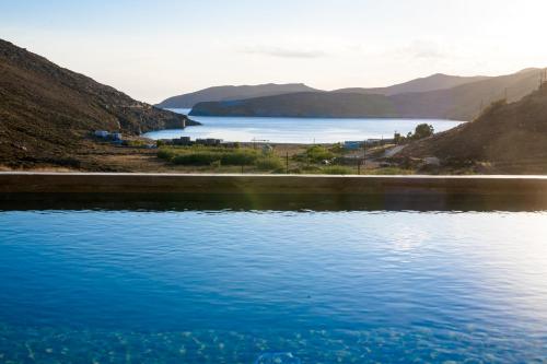 a large body of water with mountains in the background at Homa Serifos pool villas in Serifos Chora