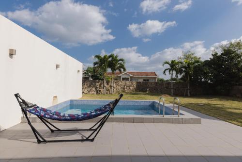 a hammock in a chair next to a swimming pool at ritomaru villa pierce miyakojima in Miyako Island