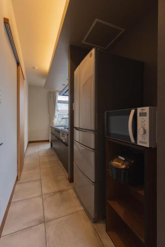 a kitchen with a refrigerator and a tile floor at ritomaru villa pierce miyakojima in Miyako Island