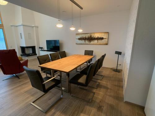 uma sala de jantar com uma mesa de madeira e cadeiras em Holidayhouse4You em Schwanau