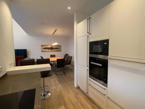 cocina y comedor con mesa y microondas en Holidayhouse4You en Schwanau