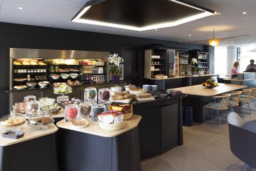 a restaurant with a buffet of food on counters at Novotel Suites Paris Montreuil Vincennes in Paris