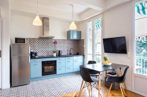 une cuisine avec des placards bleus et une table avec des chaises dans l'établissement #7 What else ? Your own quiet terrace in Nice center 10min to Beach, à Nice