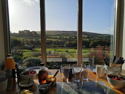 a table with a view of a field from a window at The Old Cowshed in Roundwood