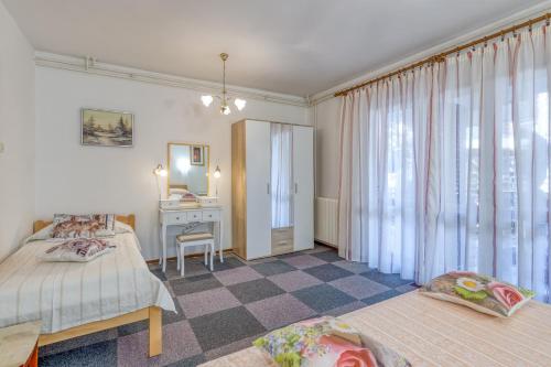 a bedroom with two beds and a desk and a mirror at Apartment Complex Nevia in Poreč