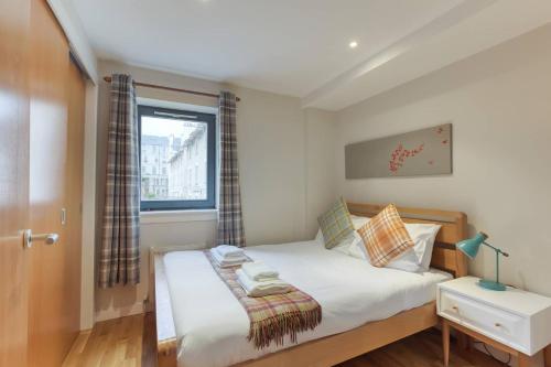 a small bedroom with a bed and a window at *Amazing Location!*In heart of the City. 2BR & Cot in Edinburgh