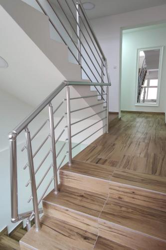 a staircase with a metal railing and wood floors at Apartmani Hani in Trebinje