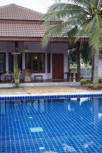 a swimming pool in front of a villa at Waterside Resort in Pran Buri