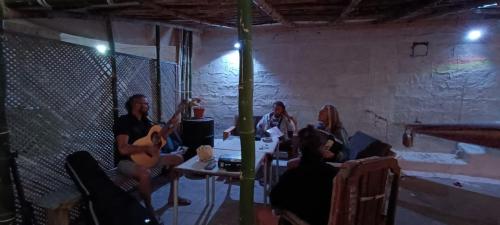 eine Gruppe von Menschen, die in einem Raum mit Instrumenten sitzen in der Unterkunft Hostel Mindelo in Mindelo