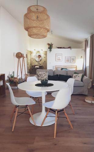 a living room with a white table and chairs at Quintinha do Sal - Casa das Flores in Alcácer do Sal