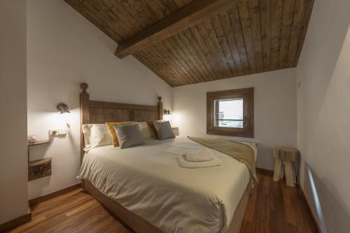 a bedroom with a large bed with a wooden ceiling at CAN ROC in Camprodon