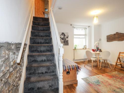 a staircase in a living room with a table at 5 Thomas Street in Llanberis