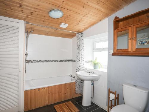 a bathroom with a sink and a tub and a toilet at 5 Thomas Street in Llanberis